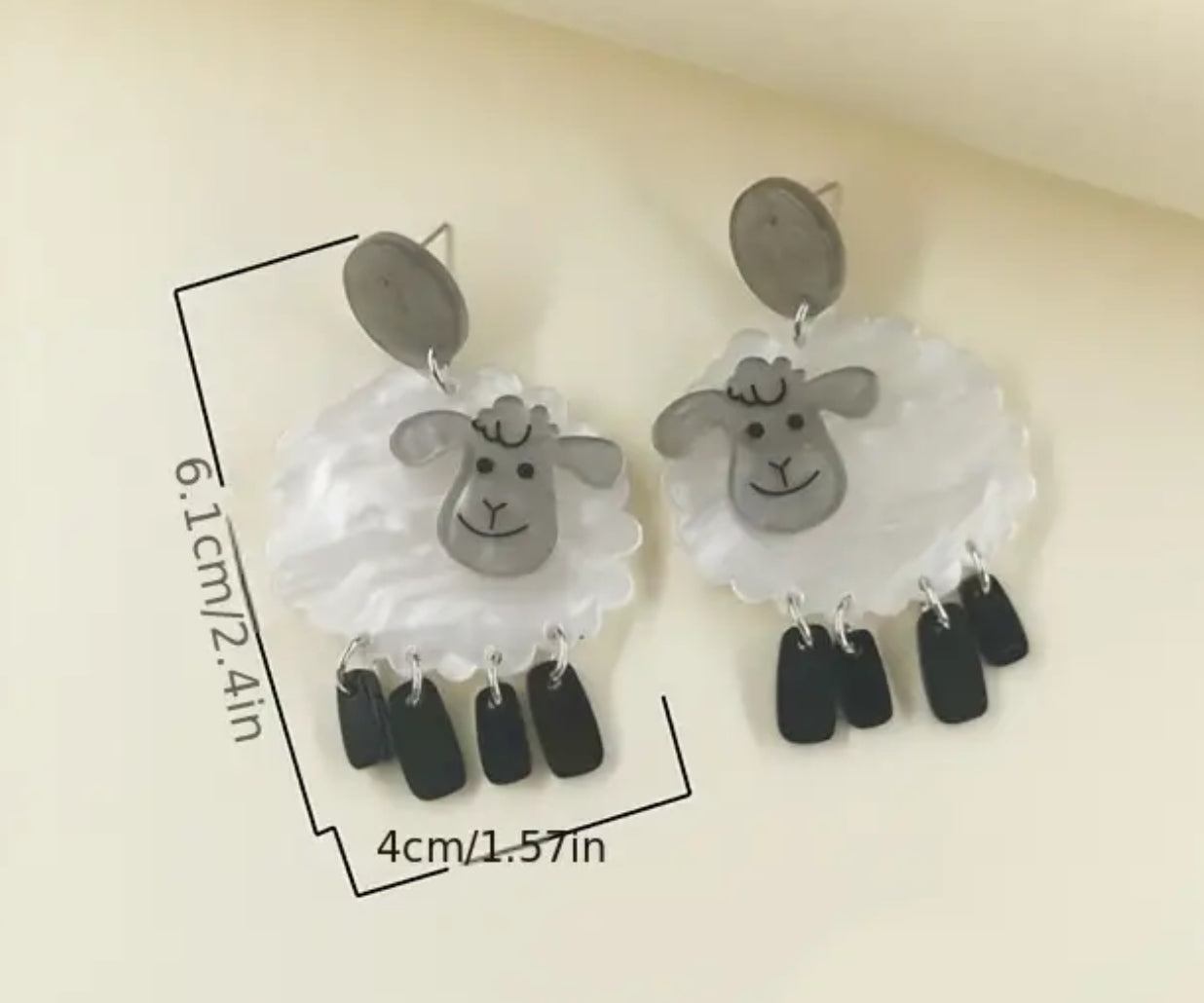 White sheep with dangling black leg earrings