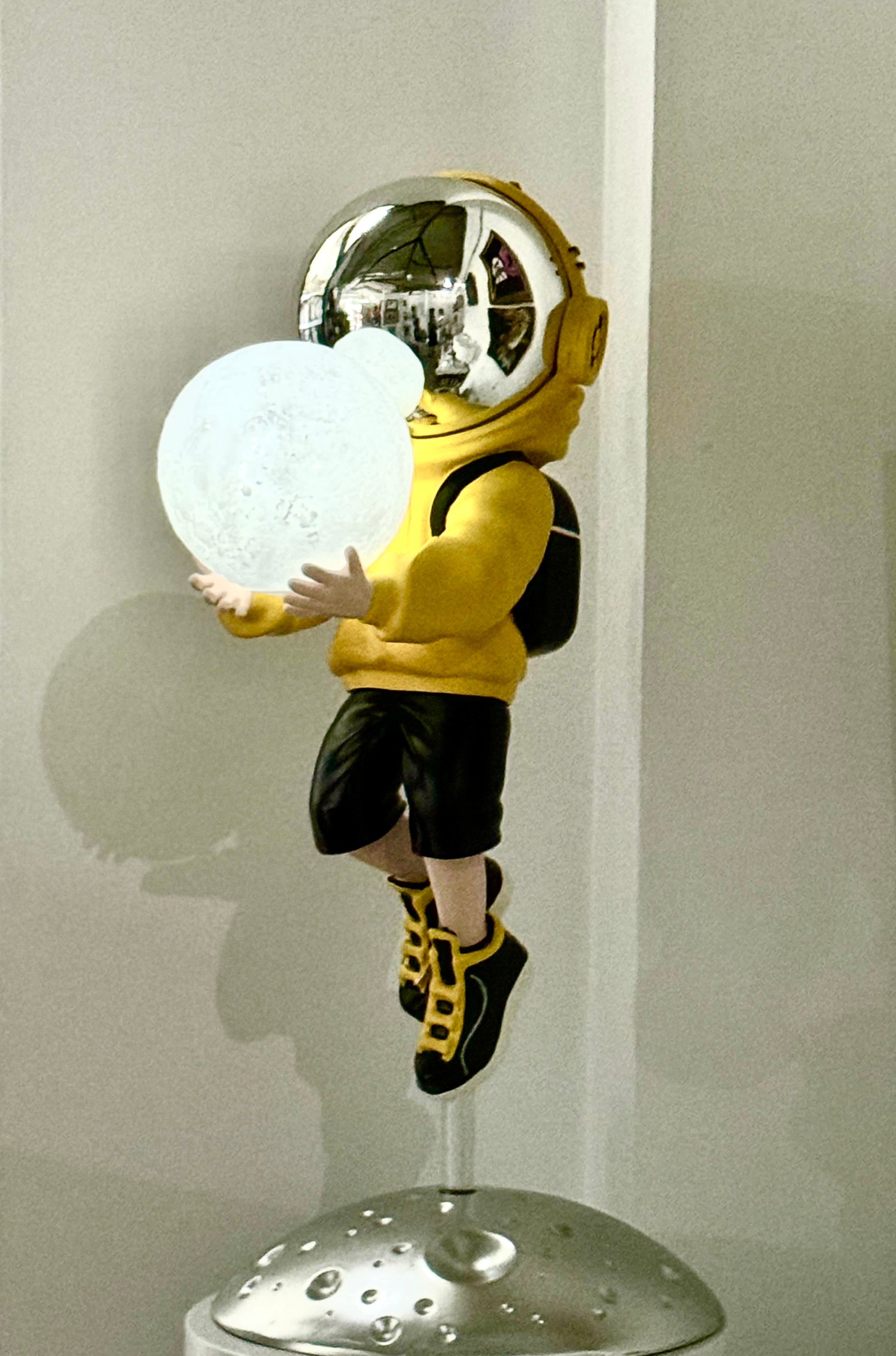 Astronaute en pull jaune avec lampe lunaire