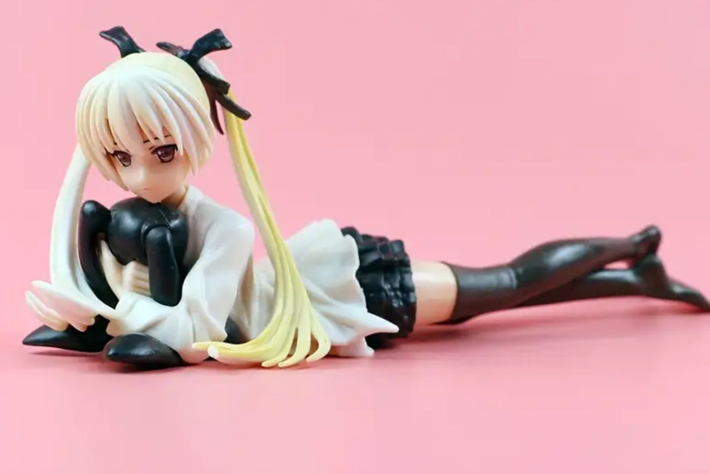 Figurine de fille d'anime allongée avec un lapin