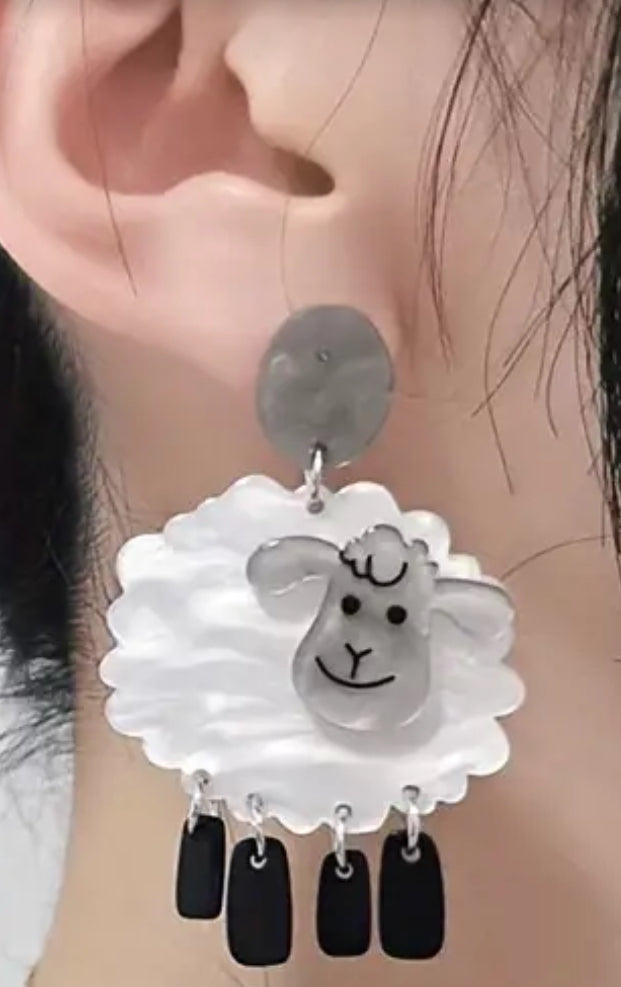 White sheep with dangling black leg earrings