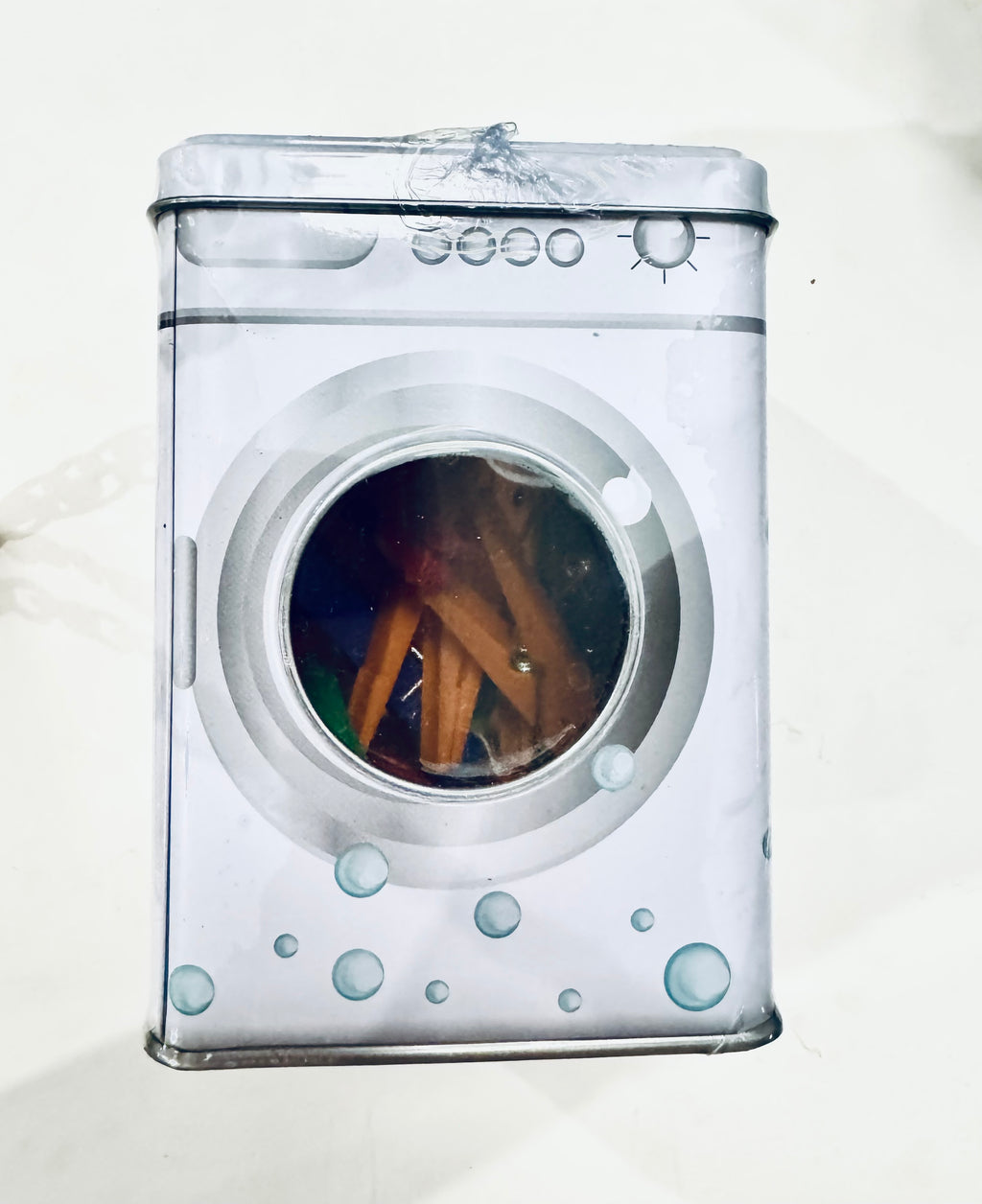 Laundry pegs in metal tin