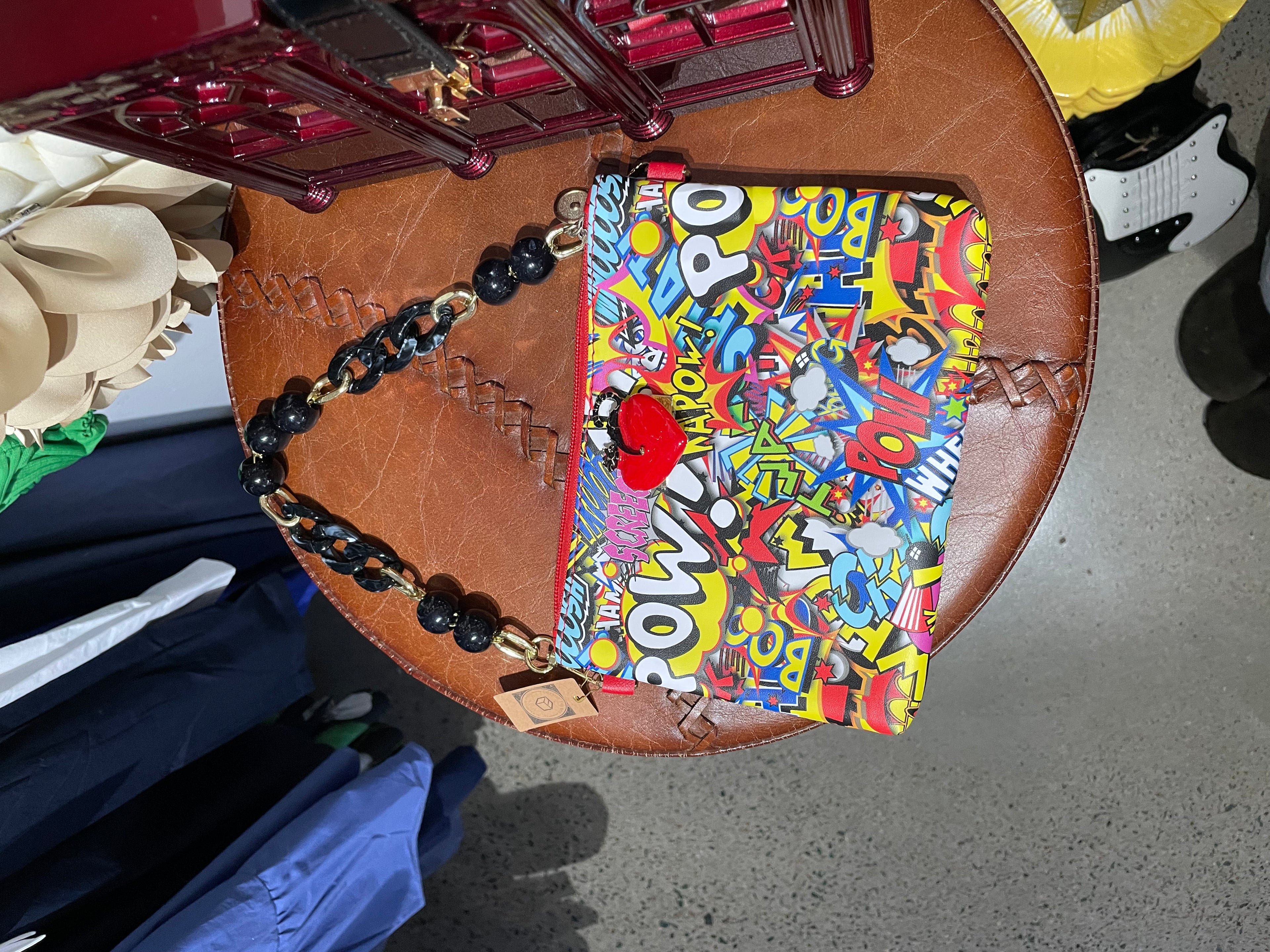 Colourful comic clutch with black strap
