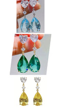 Boucles d'oreilles à tige avec pendentif en pierre précieuse.