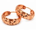 Copper engraved floral hoop earrings on white background
