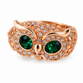 Copper owl ring with green crystal eyes on white background