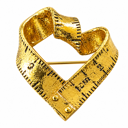 Gold-tone heart-shaped measuring tape brooch on white background
