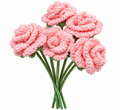 Handmade crochet pink roses with green stems on white background