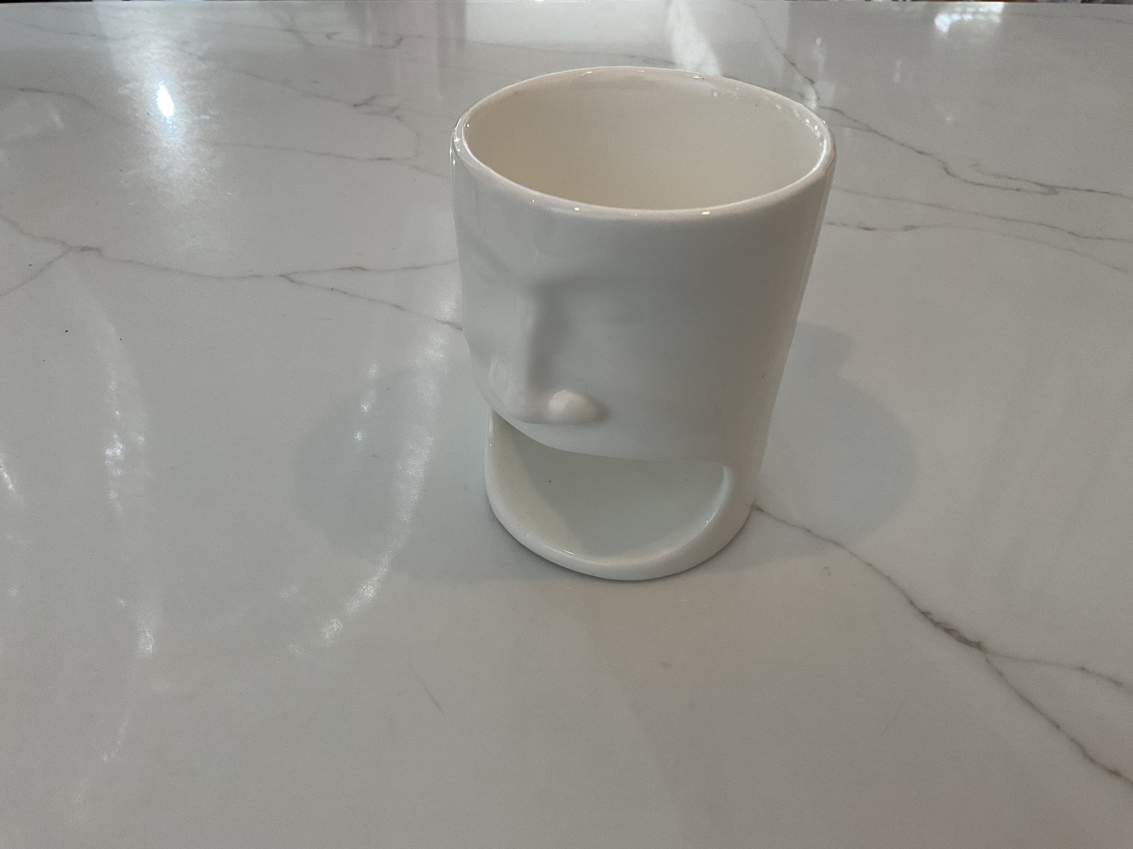 Tasse blanche avec un visage drôle