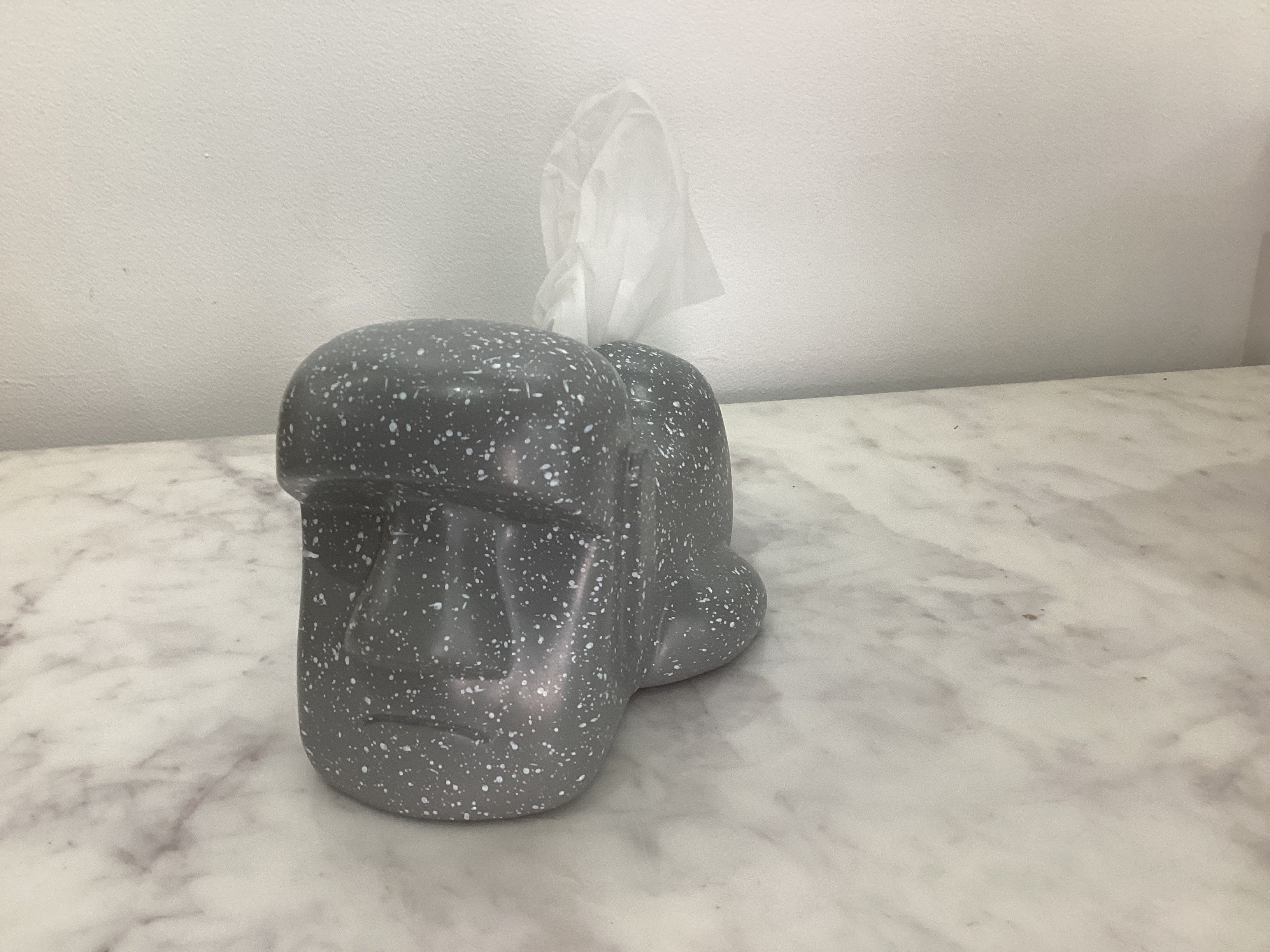 Homme de l'île de Pâques allongé sur une boîte de mouchoirs