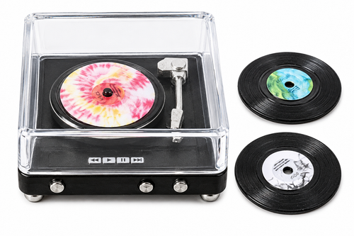 Miniature record player with three tiny vinyl records on white background