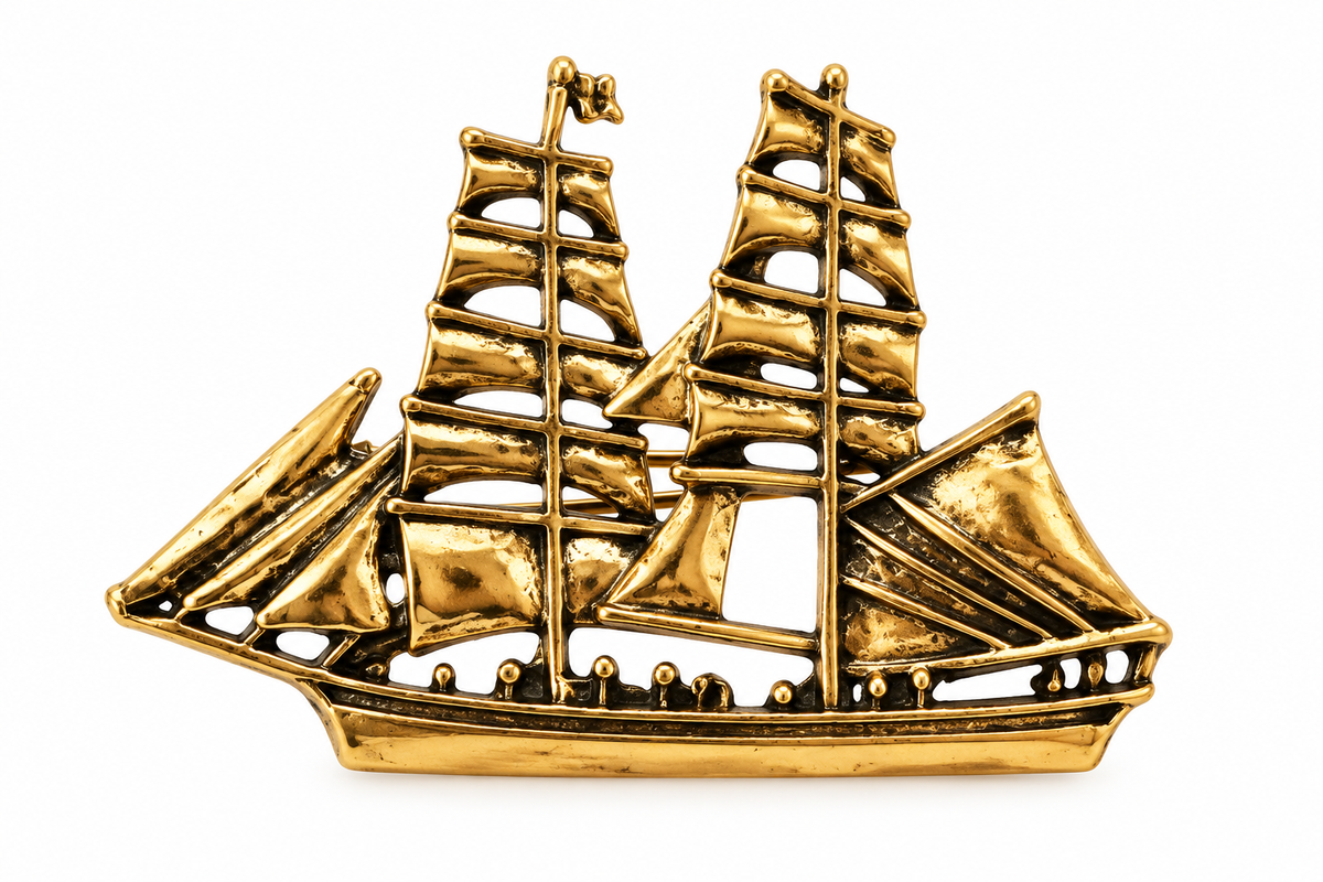Antique gold-tone sailing ship brooch on a white background