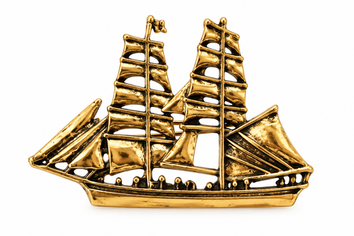Antique gold-tone sailing ship brooch on a white background